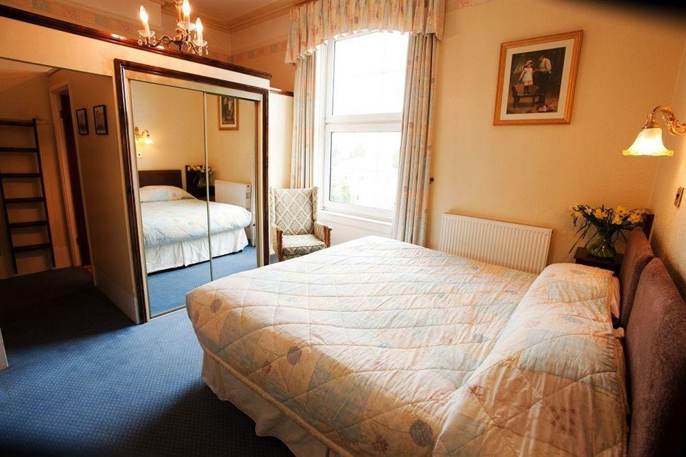 Cotswold Grange Panzió Cheltenham Kültér fotó A bedroom at the hotel