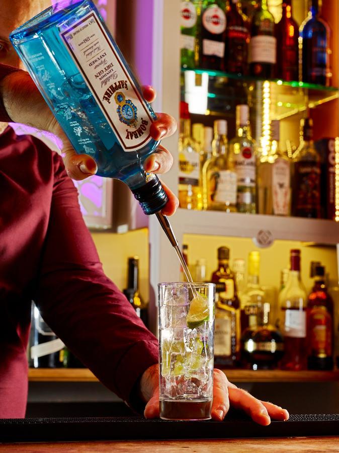 Cotswold Grange Panzió Cheltenham Kültér fotó A bartender pouring a bottle of Blue Curaçao liqueur